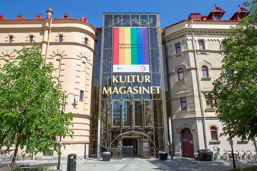 Ett foto av byggnaden Kulturmagasinet. Två stora magasinbyggnader i sten som omsluts av ett stort glasparti som håller byggnaderna samman. 