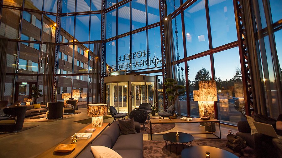 Fotografi av Hotell Södra Bergets entré med stora glasfönster.